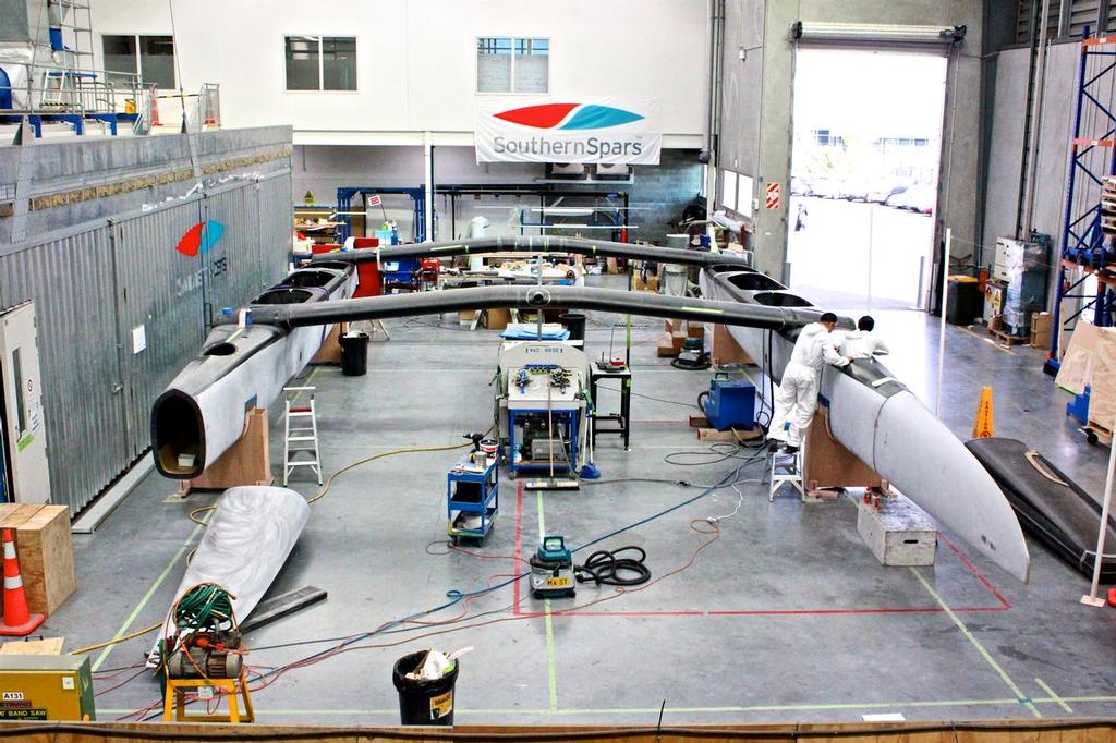 Emirates Team NZ’s AC50 is assembled in part of the Southern Spars facility in Auckland. The 2.7m long bow section is shown as being detached on the starboard (left in picture)  hull. © Southern Spars